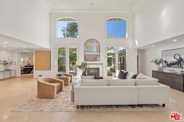 living room with a high ceiling, ornamental molding, and french doors