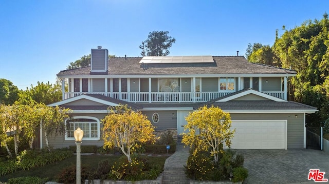 view of front facade with a garage and solar panels