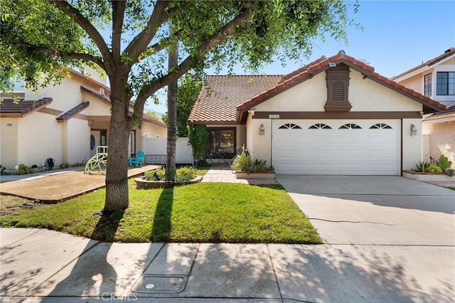 mediterranean / spanish-style house featuring a front lawn and a garage