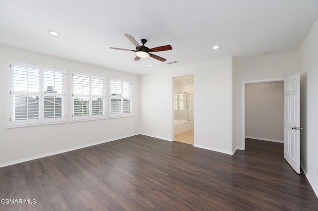 spare room with ceiling fan, dark wood-type flooring, and a wealth of natural light