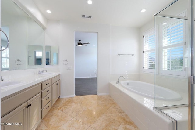 bathroom with tiled bath, vanity, ceiling fan, and tile patterned flooring