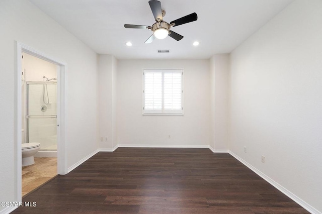 unfurnished bedroom with ensuite bathroom, ceiling fan, and dark wood-type flooring