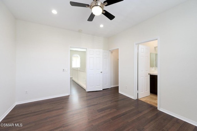 unfurnished bedroom featuring ceiling fan, dark wood-type flooring, a closet, and ensuite bath