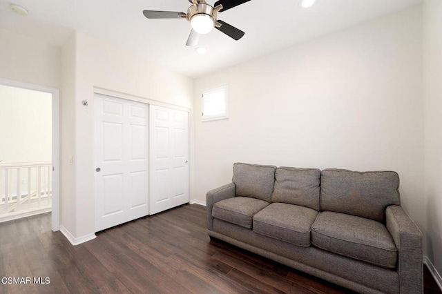 living room with ceiling fan and dark wood-type flooring