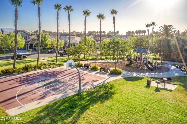 surrounding community featuring a playground, a lawn, and basketball hoop