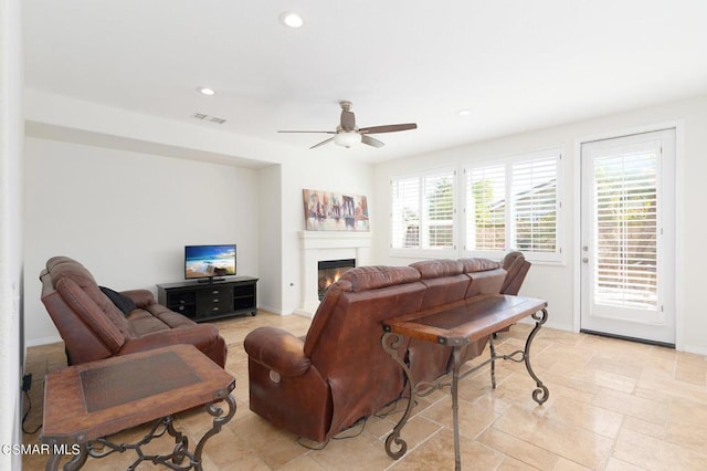 living room with ceiling fan and plenty of natural light