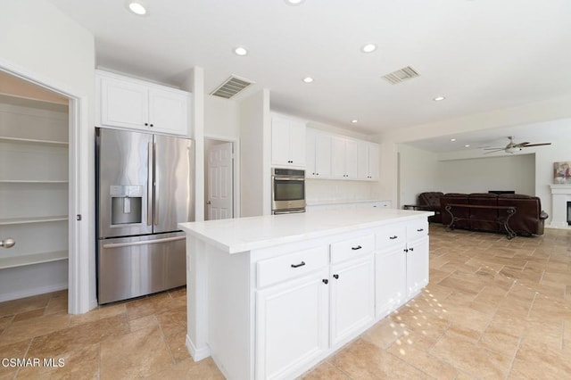 kitchen featuring ceiling fan, white cabinetry, appliances with stainless steel finishes, and a center island