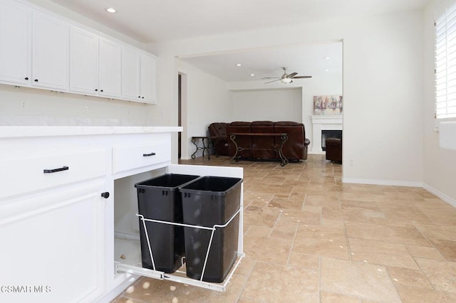 kitchen with ceiling fan and white cabinetry