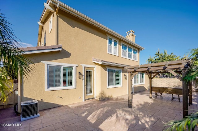 rear view of house featuring central AC, a pergola, and a patio area