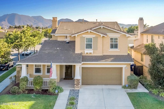 view of front of property featuring a mountain view, covered porch, and a garage