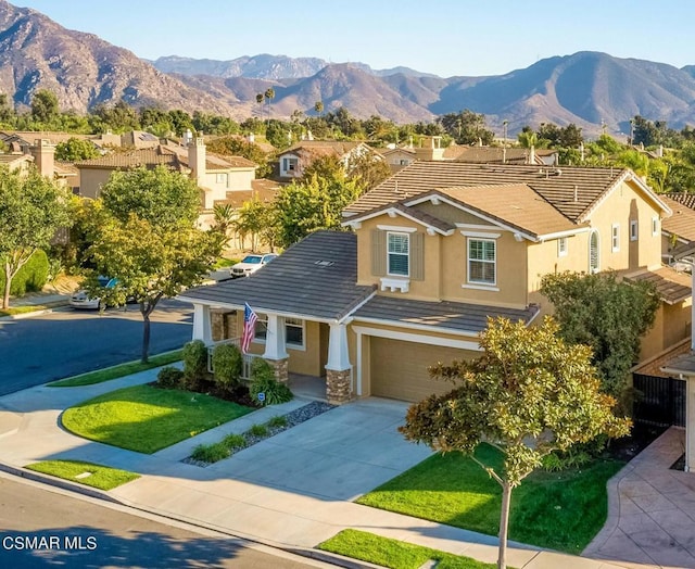 view of front of home with a front yard, a mountain view, and a garage