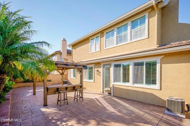 back of house featuring a patio area, central AC unit, and a pergola