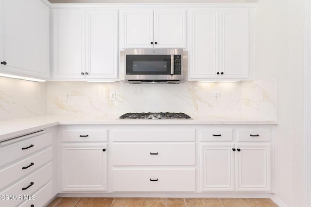 kitchen featuring backsplash, white cabinetry, and stainless steel appliances