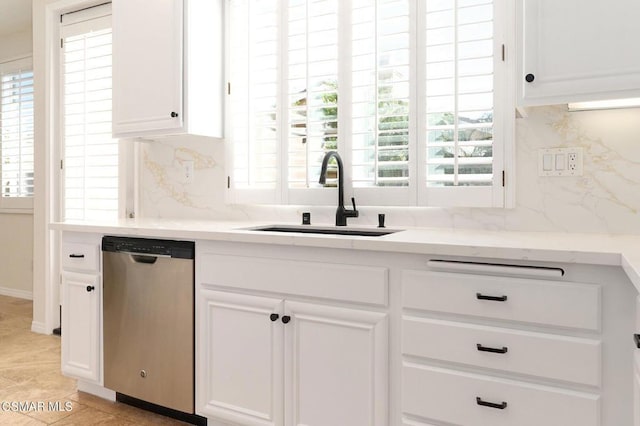 kitchen featuring decorative backsplash, stainless steel dishwasher, white cabinets, and sink