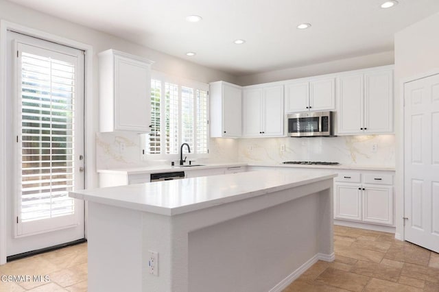 kitchen featuring white cabinets, appliances with stainless steel finishes, sink, and a kitchen island