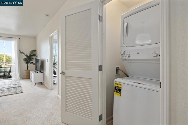 clothes washing area with light carpet and stacked washing maching and dryer