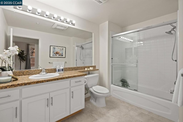 full bathroom featuring toilet, combined bath / shower with glass door, tile patterned flooring, and vanity