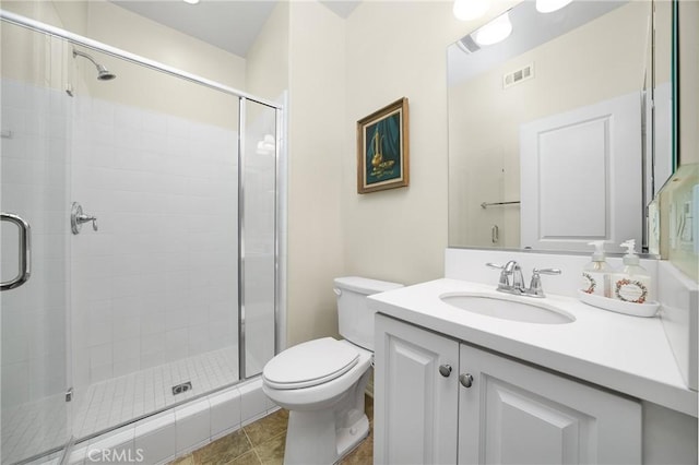 bathroom featuring toilet, tile patterned flooring, an enclosed shower, and vanity