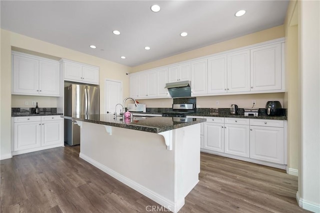 kitchen with a center island with sink, sink, appliances with stainless steel finishes, a breakfast bar area, and white cabinets