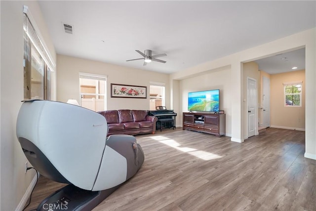 living room with ceiling fan and light hardwood / wood-style flooring