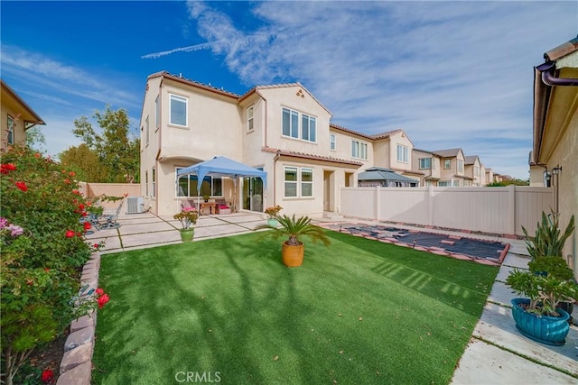 back of property with a patio area and a lawn