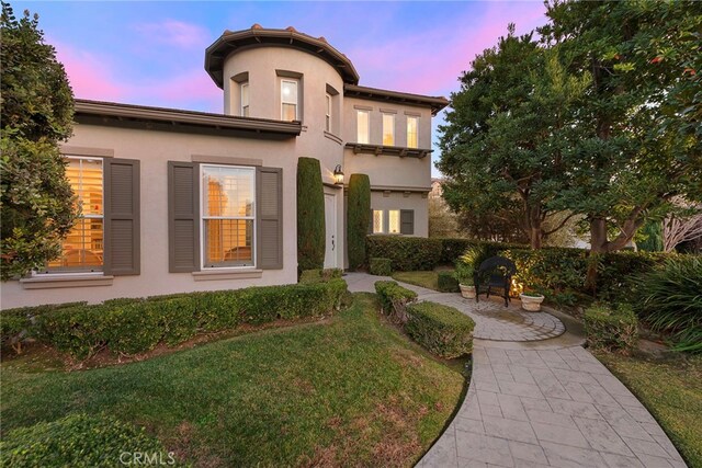 mediterranean / spanish house featuring a yard