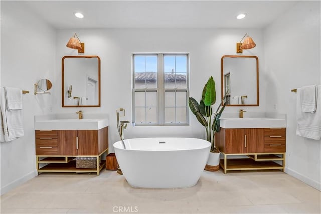 bathroom with tile patterned flooring, a bath, and vanity