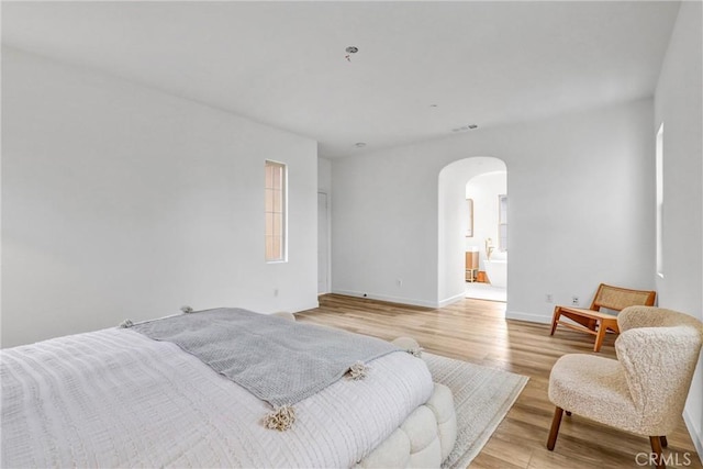 bedroom featuring ensuite bathroom and light hardwood / wood-style flooring