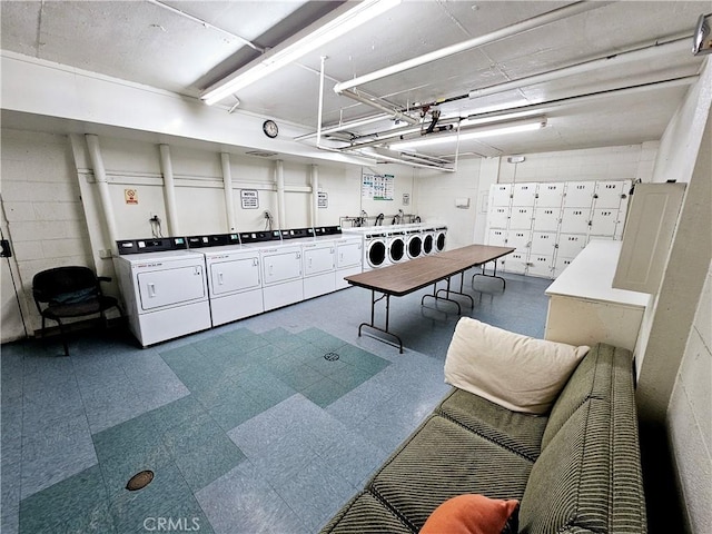 interior space with a garage, independent washer and dryer, concrete block wall, and tile patterned floors