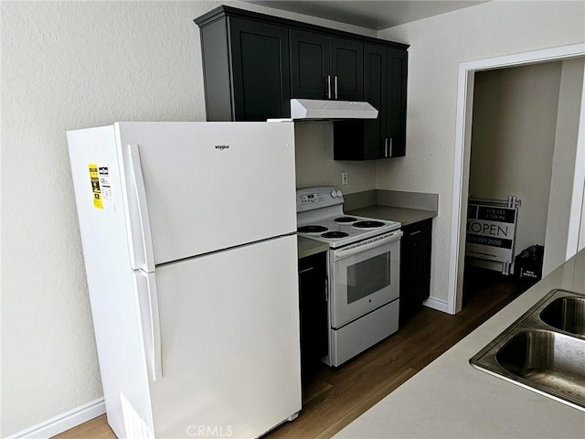 kitchen with dark hardwood / wood-style flooring, sink, and white appliances