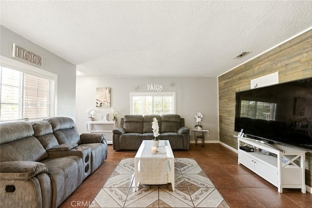 tiled living room featuring a textured ceiling and wood walls