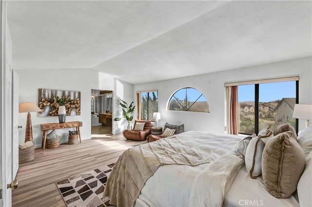 bedroom featuring lofted ceiling and light hardwood / wood-style floors