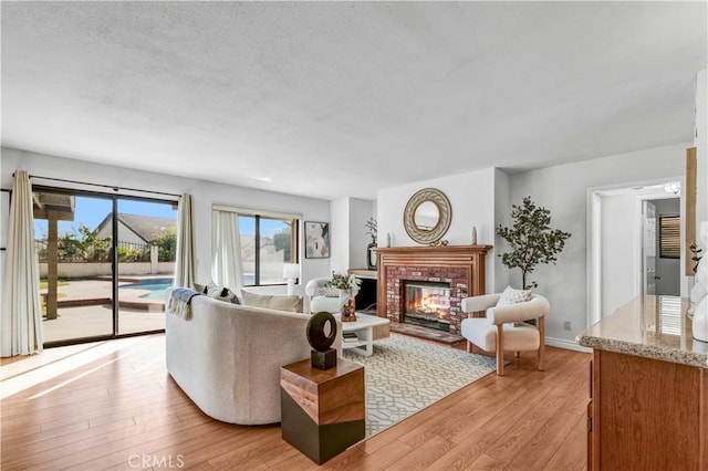 living room featuring a brick fireplace and light wood-type flooring