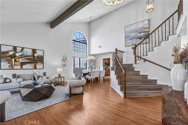 living room featuring beam ceiling, high vaulted ceiling, a chandelier, and hardwood / wood-style flooring