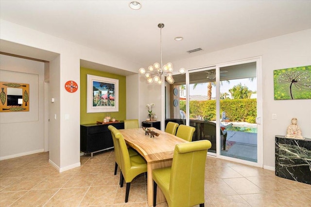 dining area featuring light tile patterned flooring and an inviting chandelier