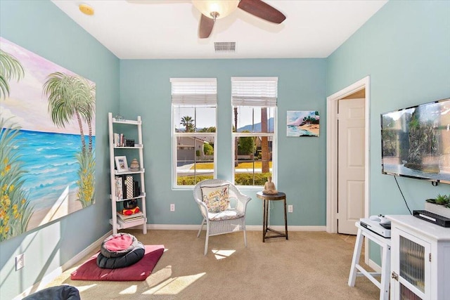 living area featuring ceiling fan and light colored carpet