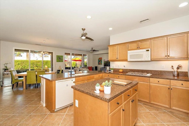 kitchen featuring white appliances, a kitchen island, sink, kitchen peninsula, and ceiling fan