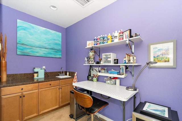 carpeted home office featuring sink