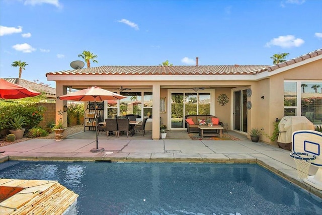 view of swimming pool featuring ceiling fan, an outdoor living space, and a patio