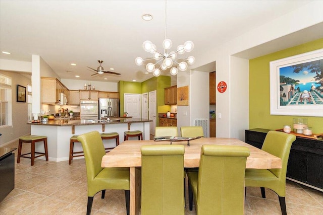 dining area with light tile patterned floors and ceiling fan with notable chandelier