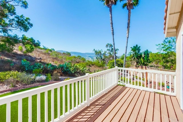 wooden terrace with a mountain view and a lawn