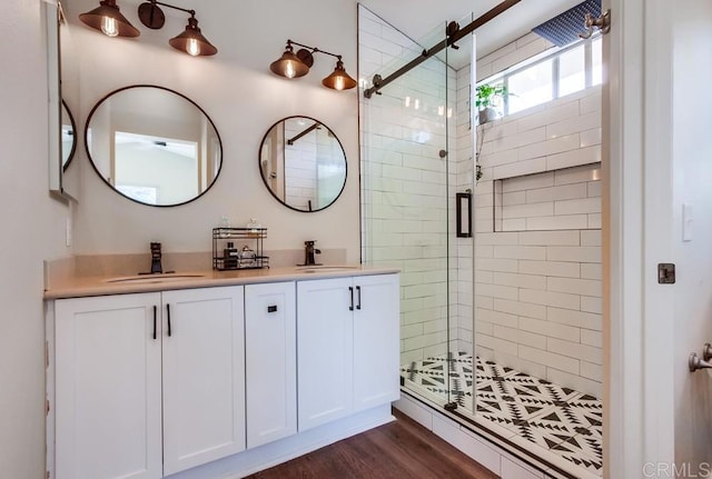 bathroom featuring a shower with shower door, wood-type flooring, and vanity