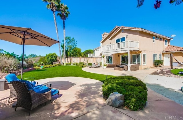 back of property featuring an outdoor living space, a yard, a balcony, and a patio