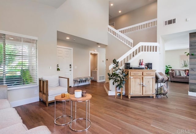 living room with a high ceiling and hardwood / wood-style floors