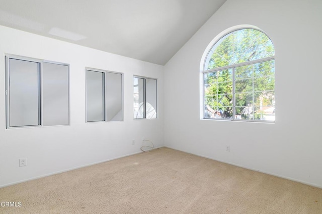 carpeted empty room featuring vaulted ceiling