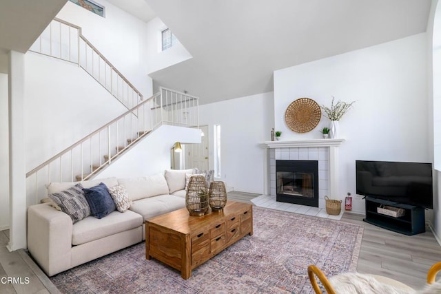 living room featuring hardwood / wood-style floors, a towering ceiling, and a fireplace