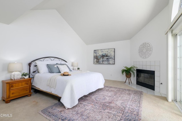 bedroom with light carpet, a tile fireplace, and high vaulted ceiling