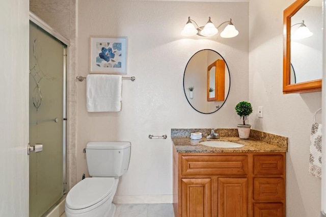 bathroom with tile patterned floors, vanity, a shower with shower door, and toilet