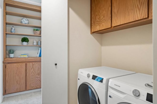 laundry area featuring separate washer and dryer and cabinets