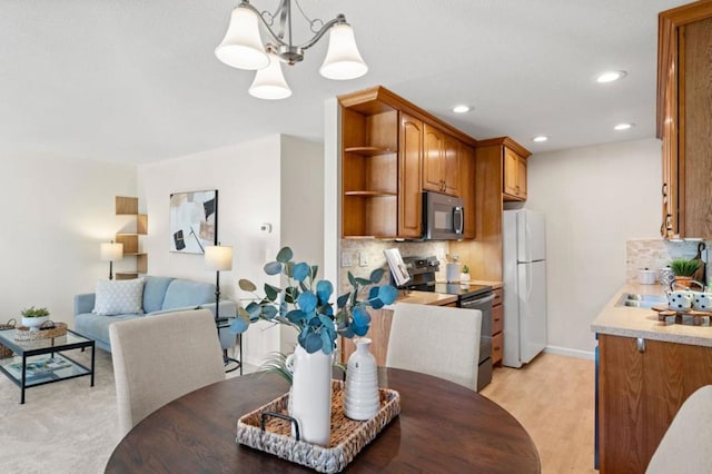 dining room with sink, light hardwood / wood-style floors, and a notable chandelier